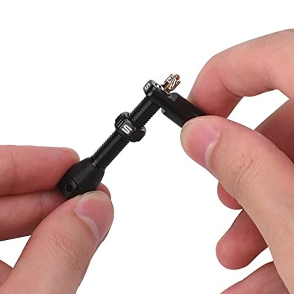 Hands installing a black tubeless valve stem with exposed valve threads