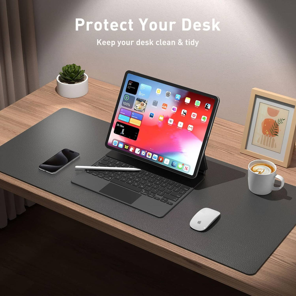 Gray desk pad on wooden desk with laptop, phone, and mouse