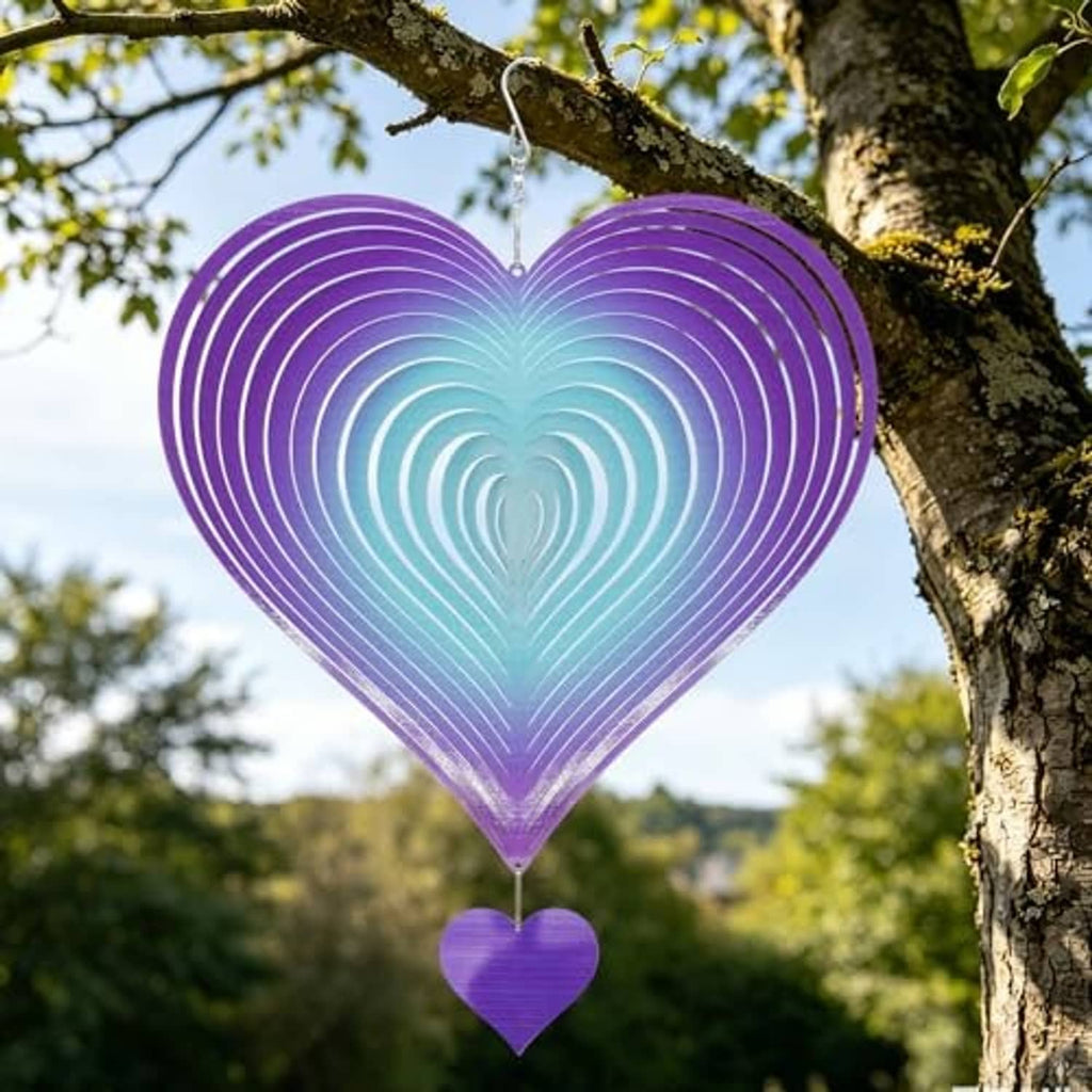 Heart wind spinner with purple-blue gradient rings and small heart charm, hanging from tree branch.