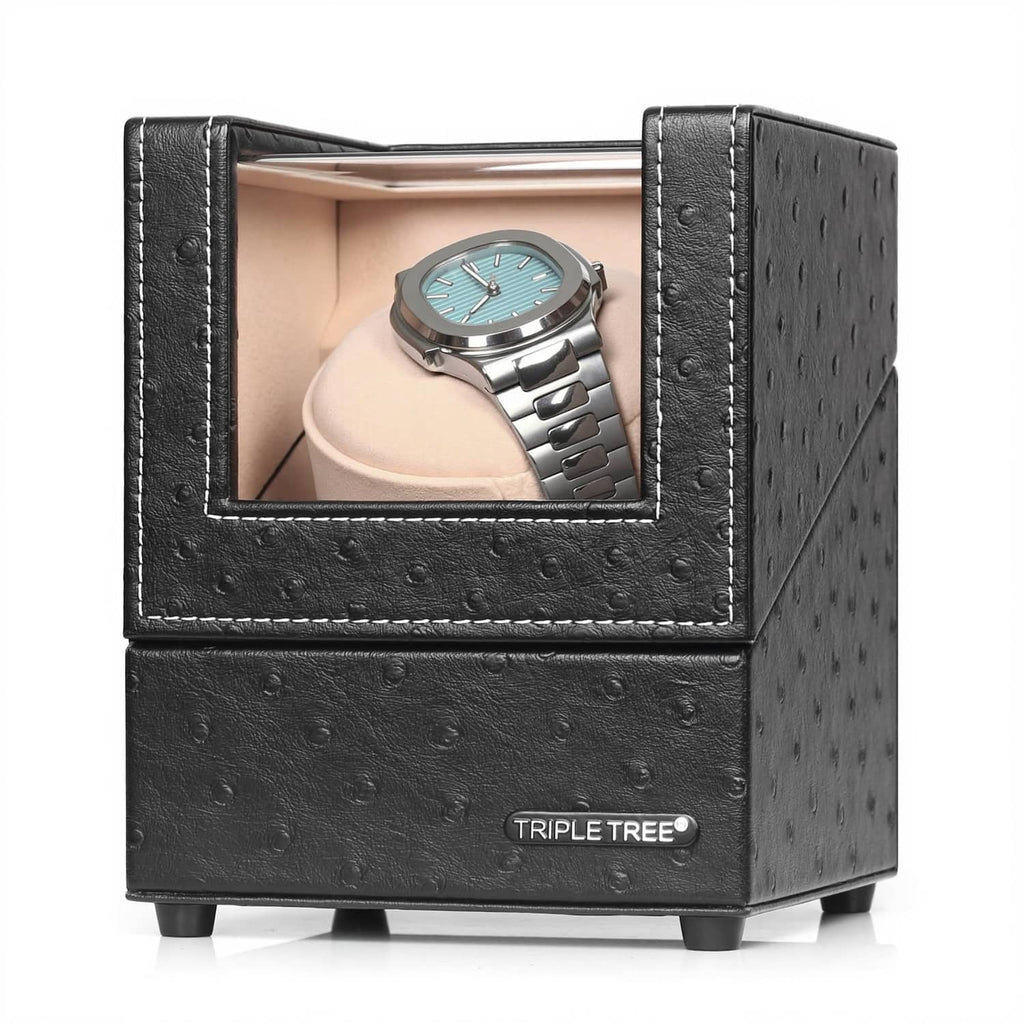 Black single watch winder with open window and beige plush pillow, holding a wristwatch