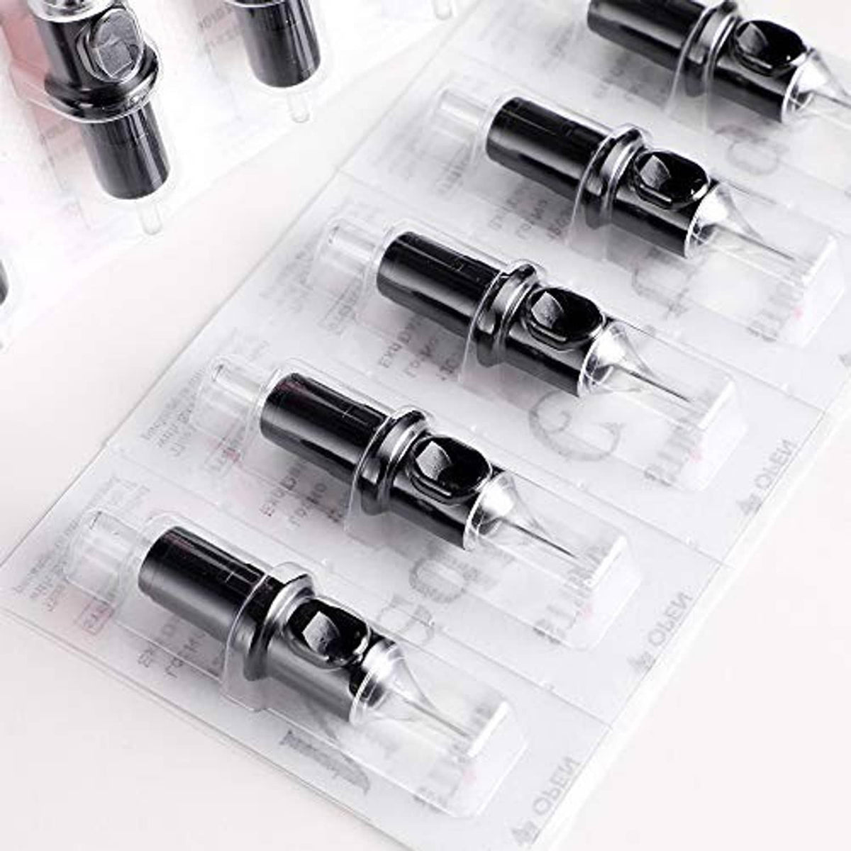 Disposable tattoo cartridges with black needle housings in clear blister packaging