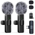 Pair of black wireless lavalier microphones with gray furry windshields and receiver clip