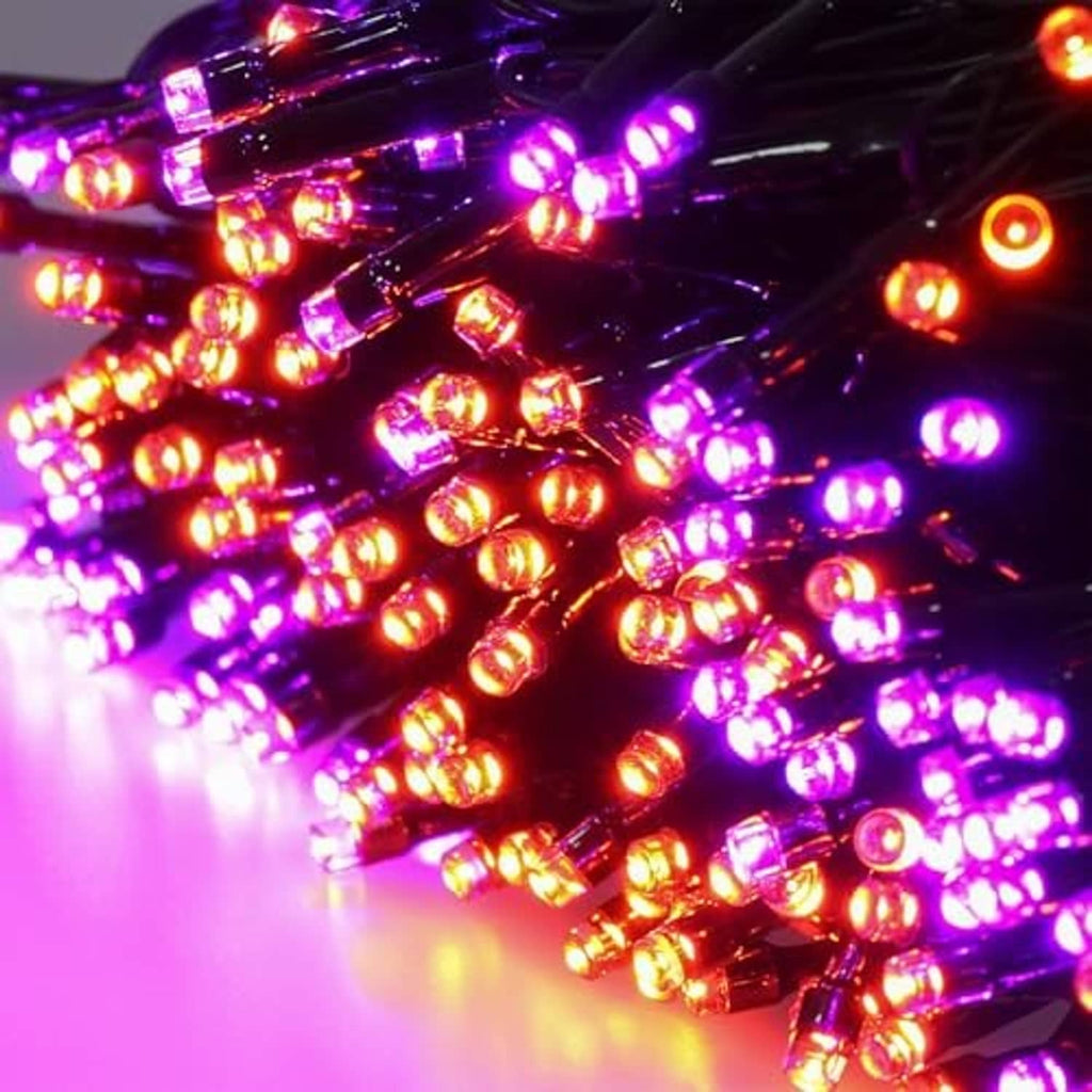 Dense LED bulbs on string lights with purple and orange glow on green wire.