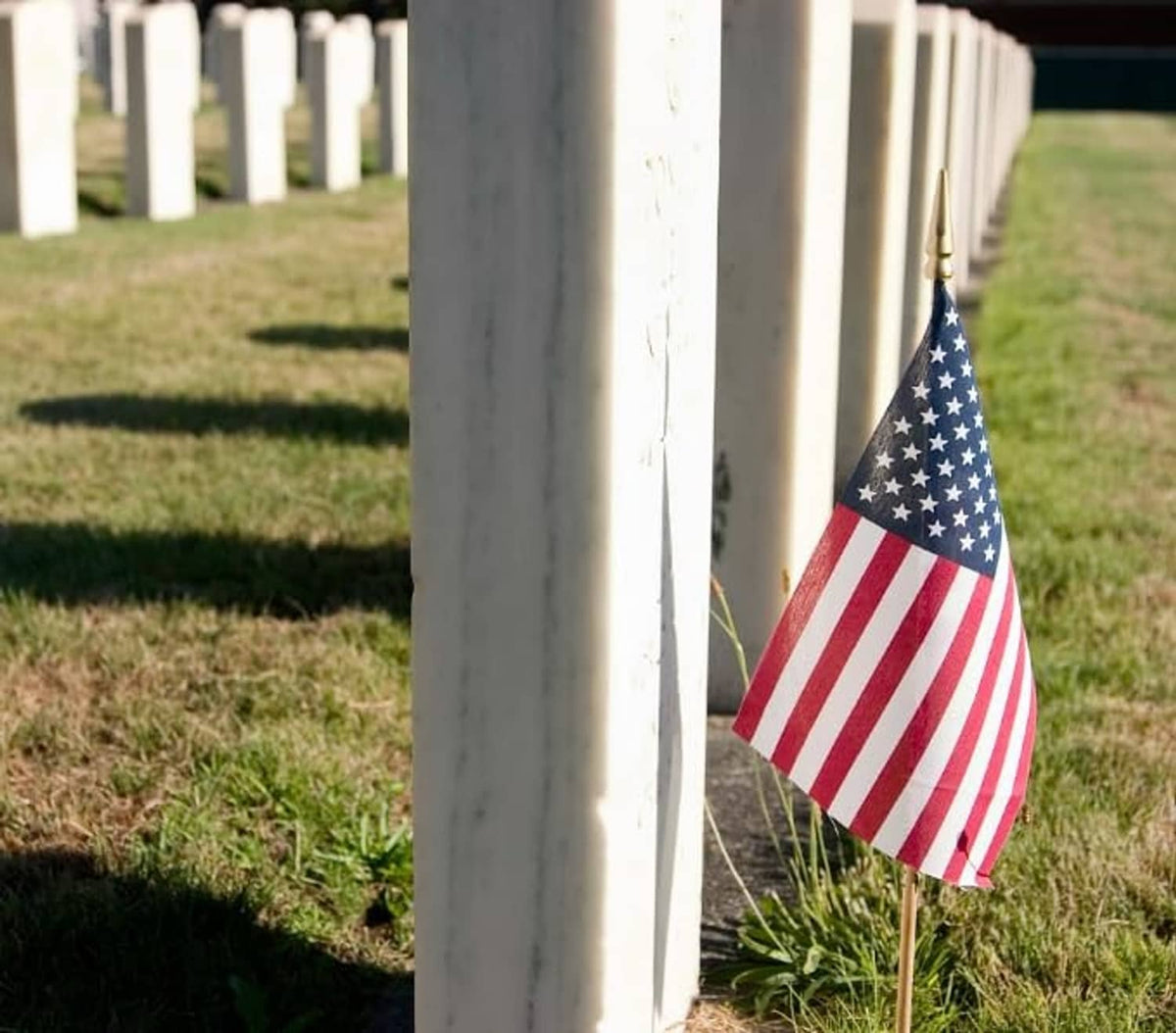 Small American flag lawn flag on wooden stake, red stripes and blue star field