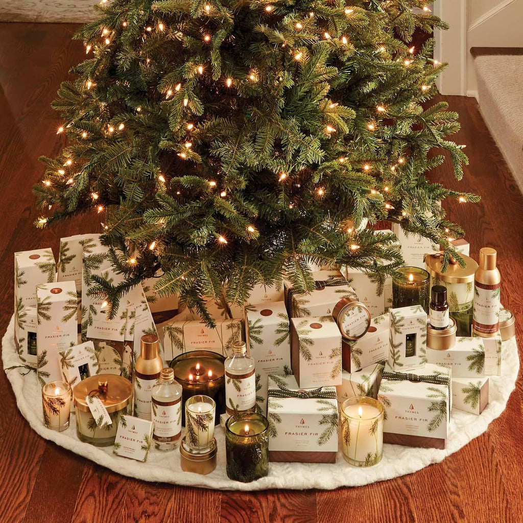 Frasier Fir candle gift set displayed on a rug among lit Christmas tree lights