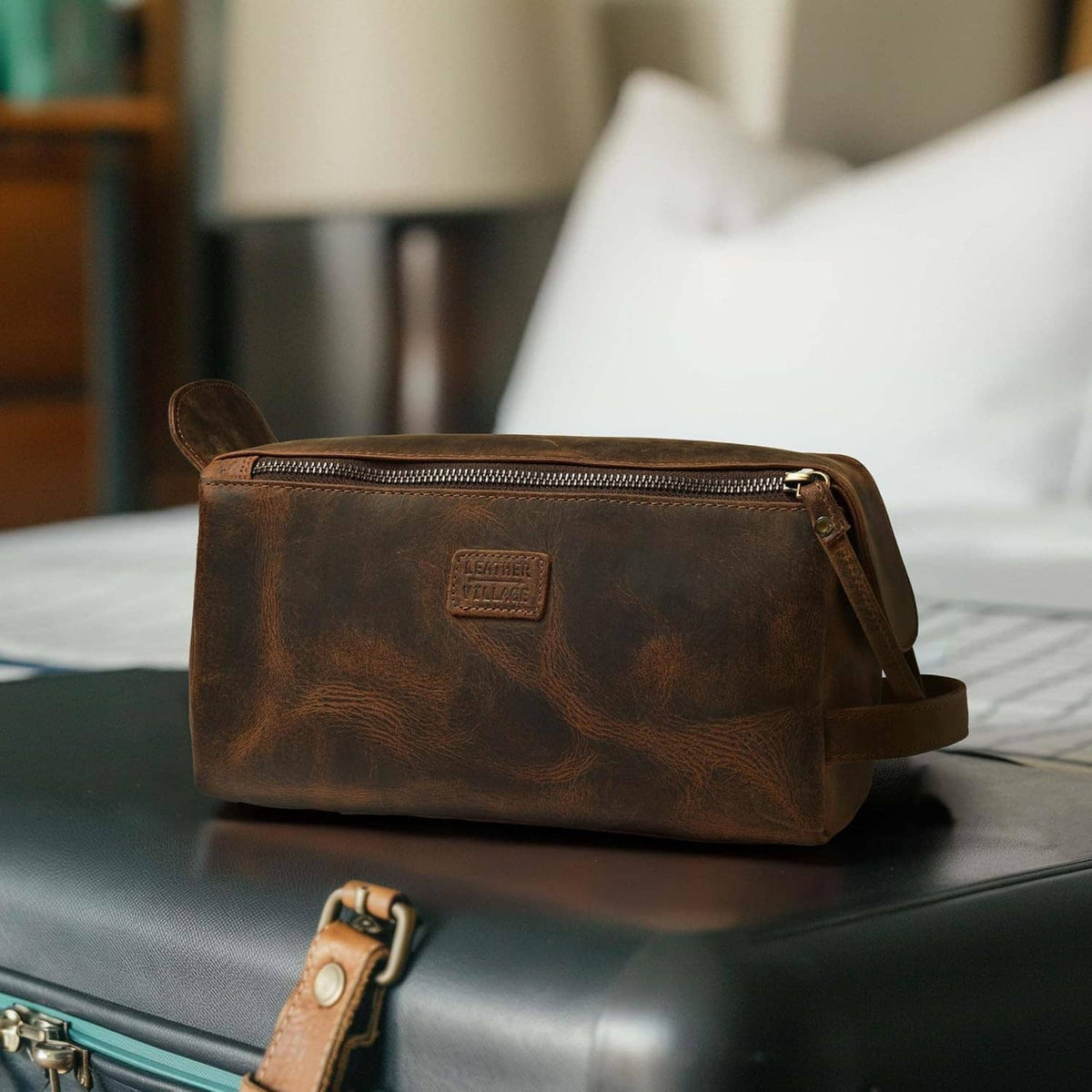 Brown leather toiletry bag with side handle strap and front zip pocket