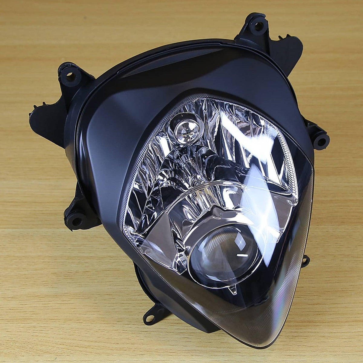 Front headlight assembly with clear projector lens and black housing, mounting tabs visible