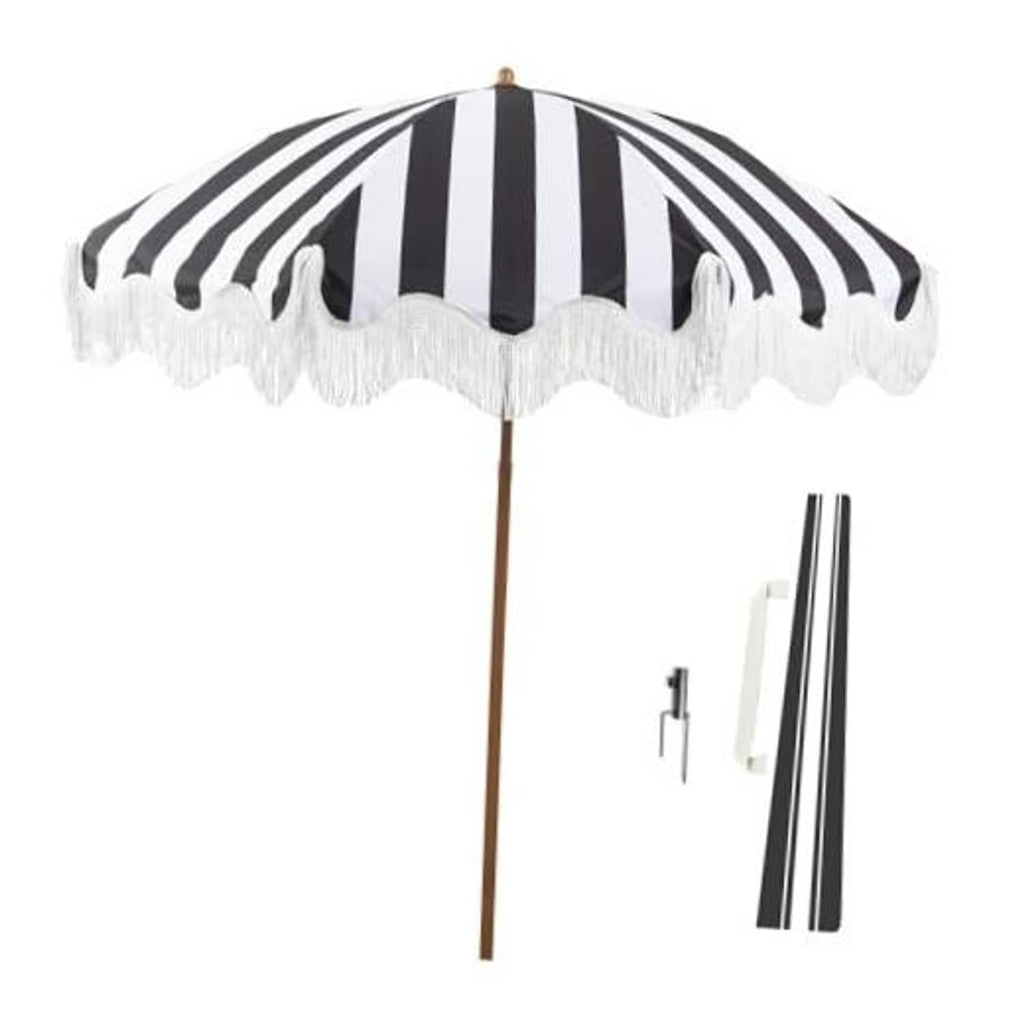Black-and-white striped patio umbrella with white tassel fringe and wooden pole