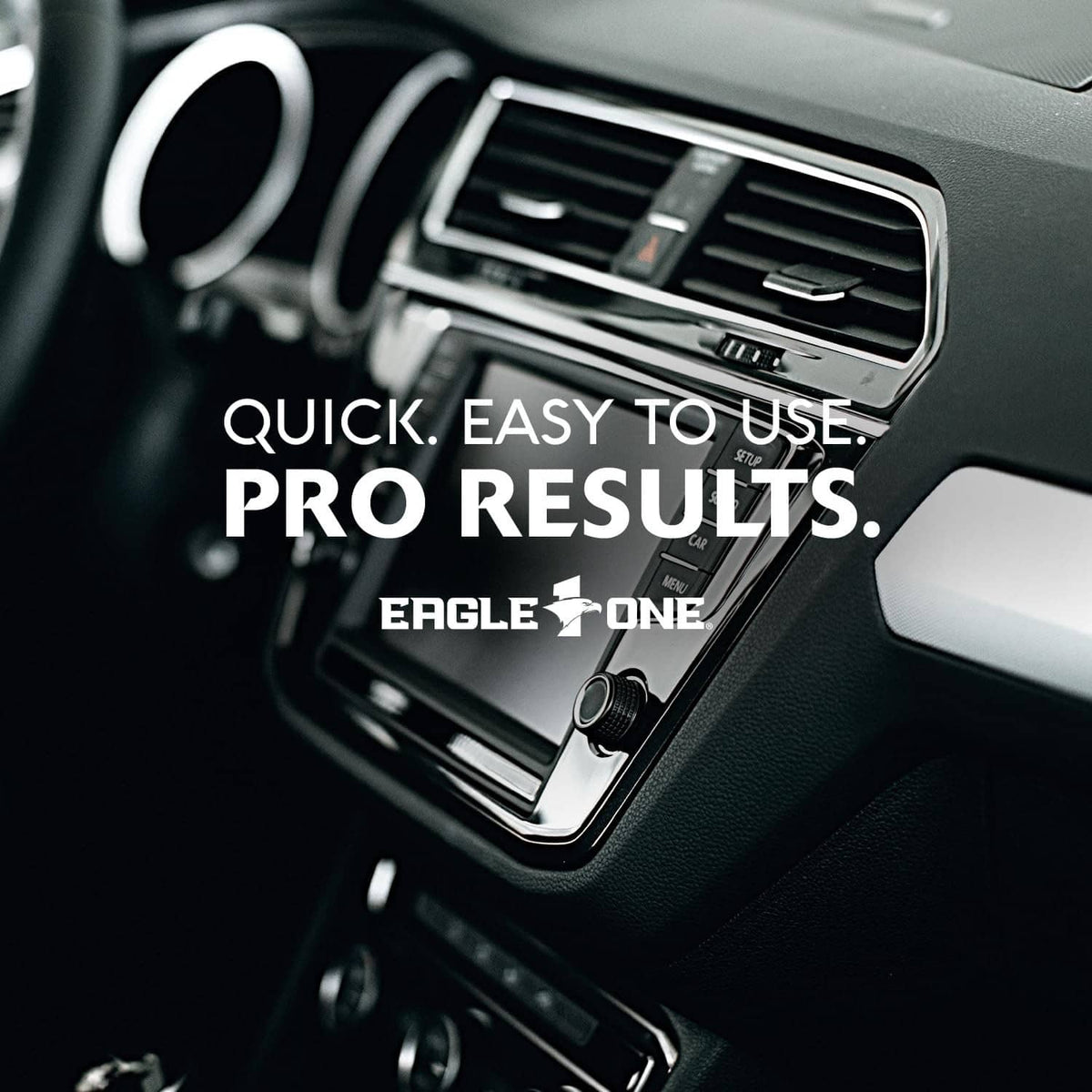 Interior detailer spray bottle near dashboard air vent and control knobs