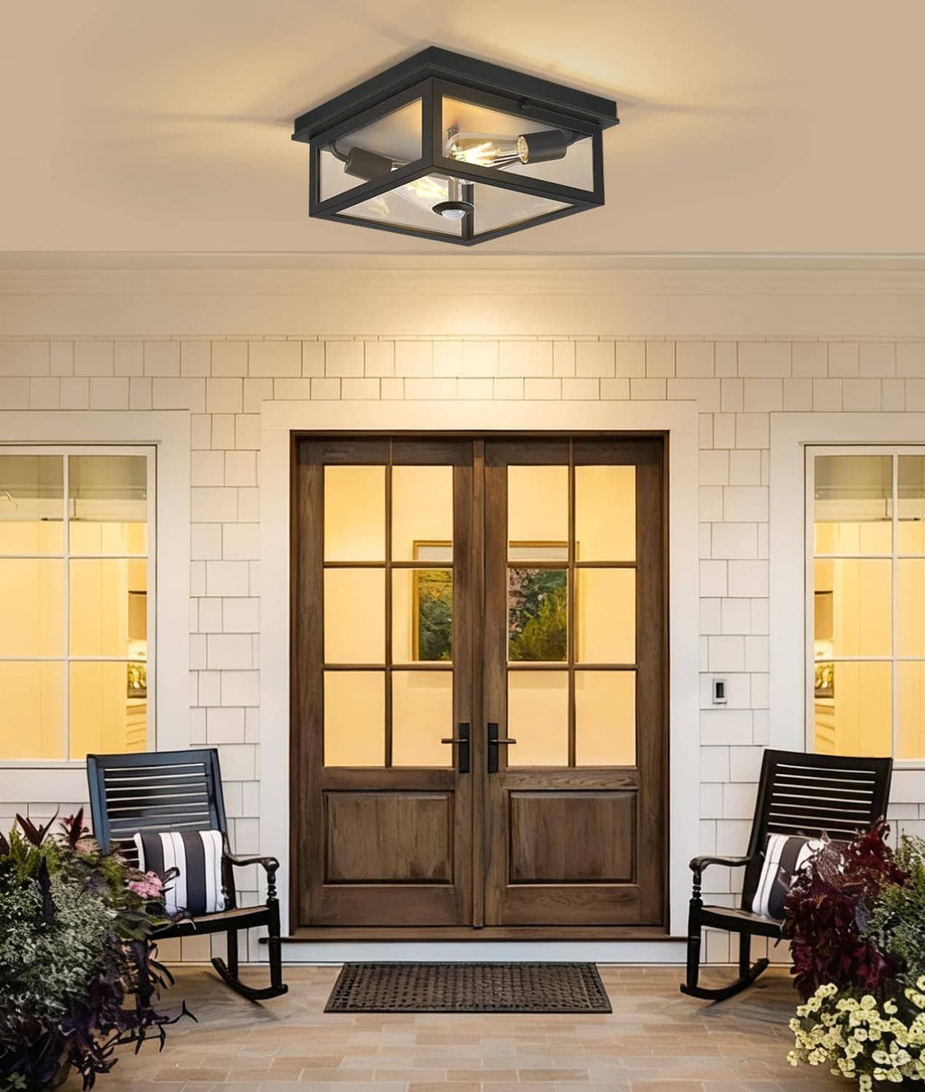 Black flush-mount outdoor ceiling light above the entry door with exposed bulb.