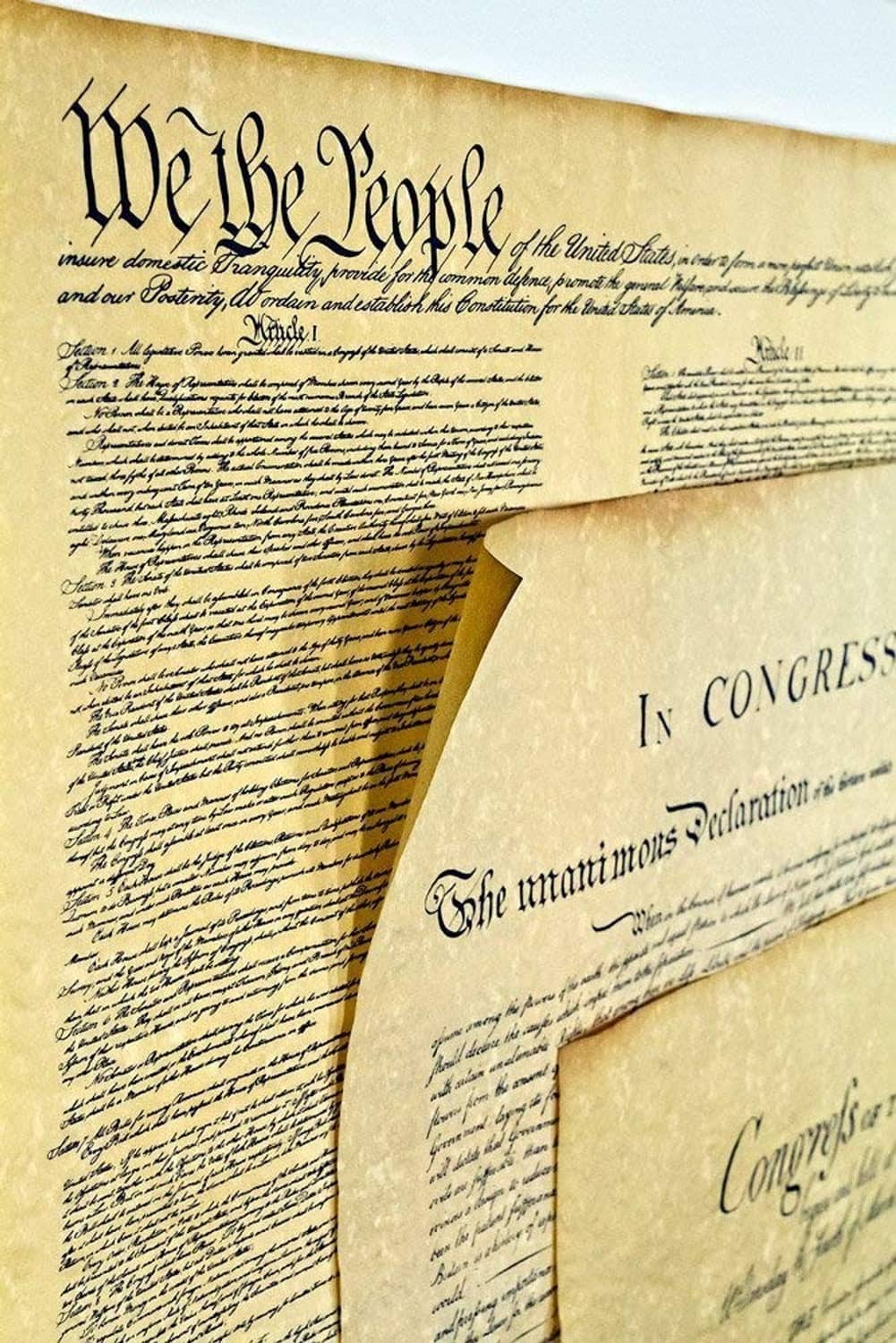 Three parchment-style printed papers showing In Congress text and layered corners.