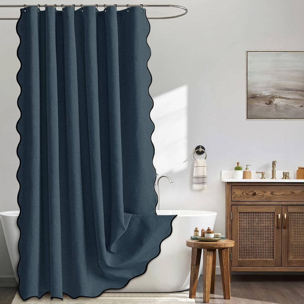 Navy blue scalloped shower curtain with metal hooks, full-length pleated fabric.