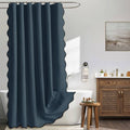 Navy blue scalloped shower curtain with metal hooks, full-length pleated fabric.