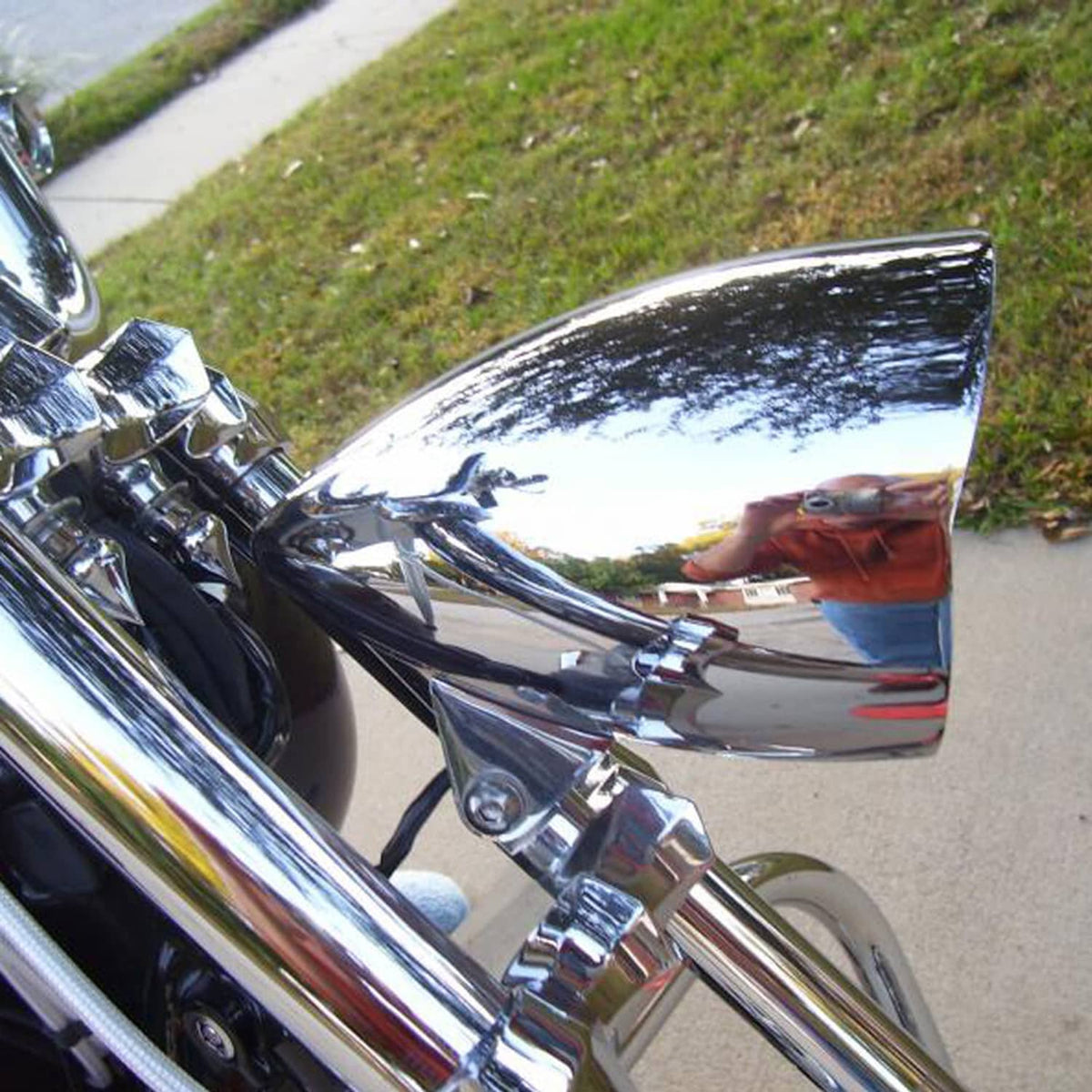 Chrome bullet headlight with clear lens and chrome bracket mounted on a motorcycle