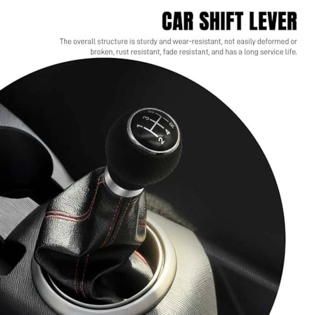 Black round gear shift knob with silver trim on leather shifter boot