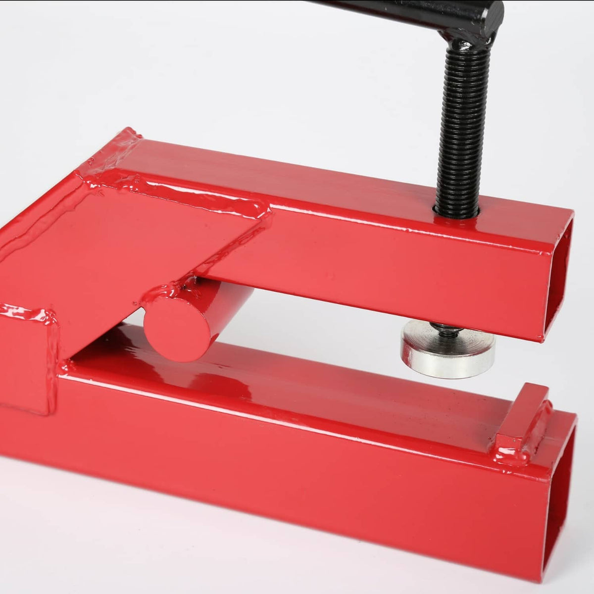 Red hitch ball mount receiver clamp with steel spacer washers and threaded rod, close-up