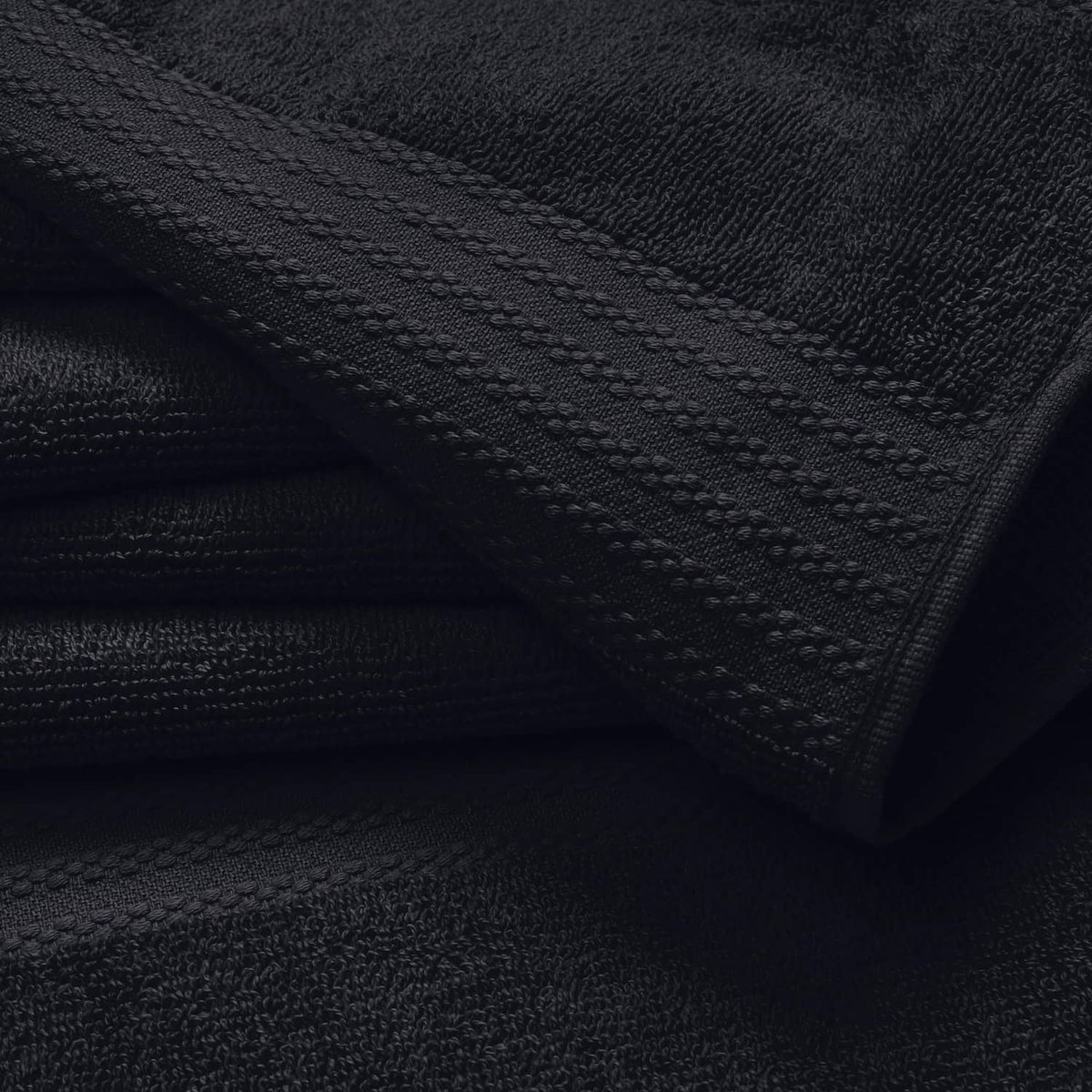 Black hand towel close-up with stitched border and textured looped fabric