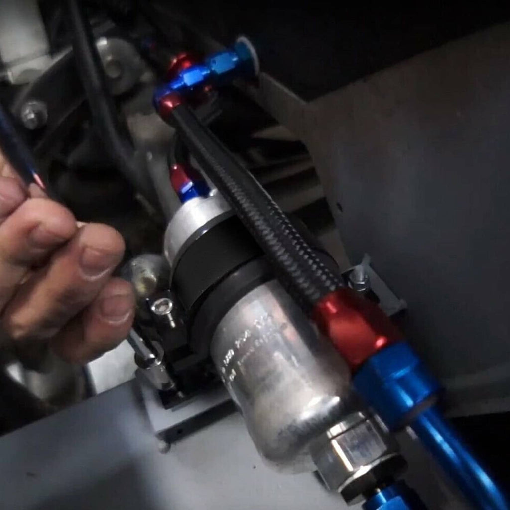 Black fuel pump bracket clamp installed in engine bay with braided hose connections