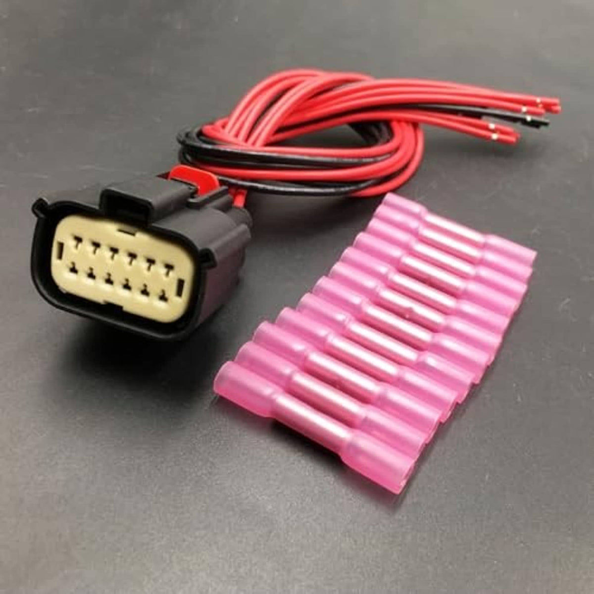 Headlight connector with red wire harness and pink terminal insulator covers