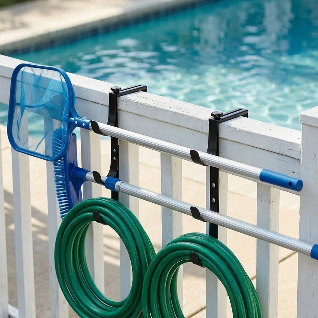 Black pool fence hooks holding pool hose and accessories on fence rail