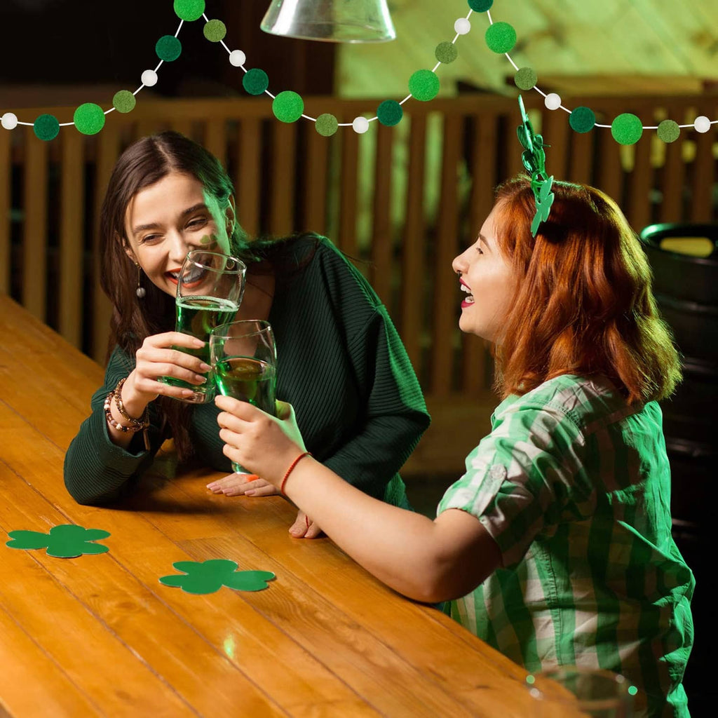 Green felt ball garland draped along the tabletop edge with white beads