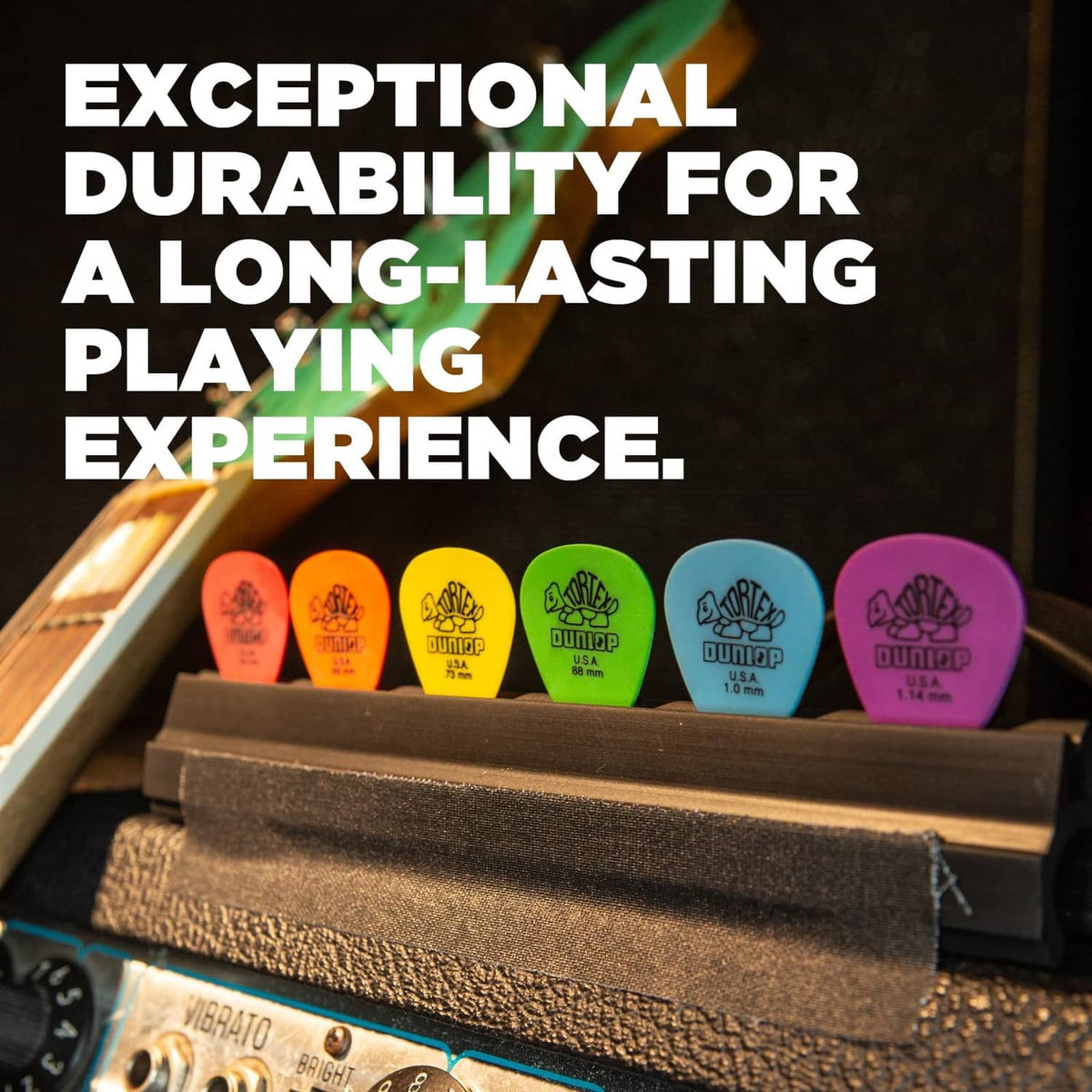 Assorted bright Dunlop Tortex guitar picks standing in a display tray.
