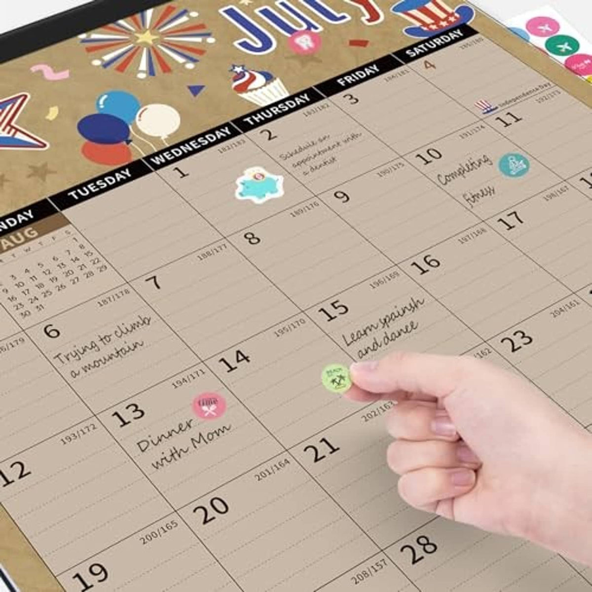 Large July monthly desk calendar with colorful stars, rockets, and date grid