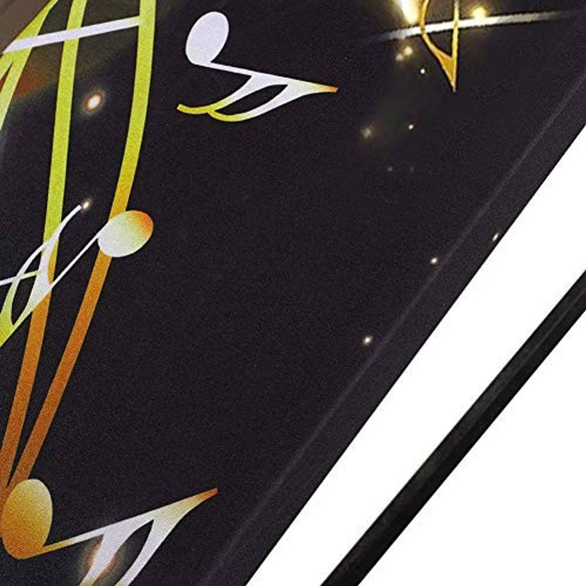 Close-up of dark piano dust cover fabric with gold musical notes and reflections