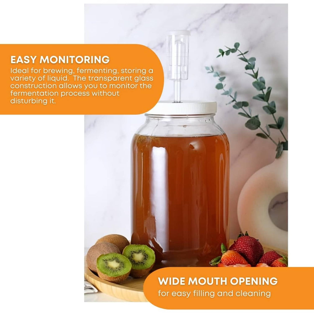 Large clear wide-mouth glass jar with airlock lid, filled with amber liquid