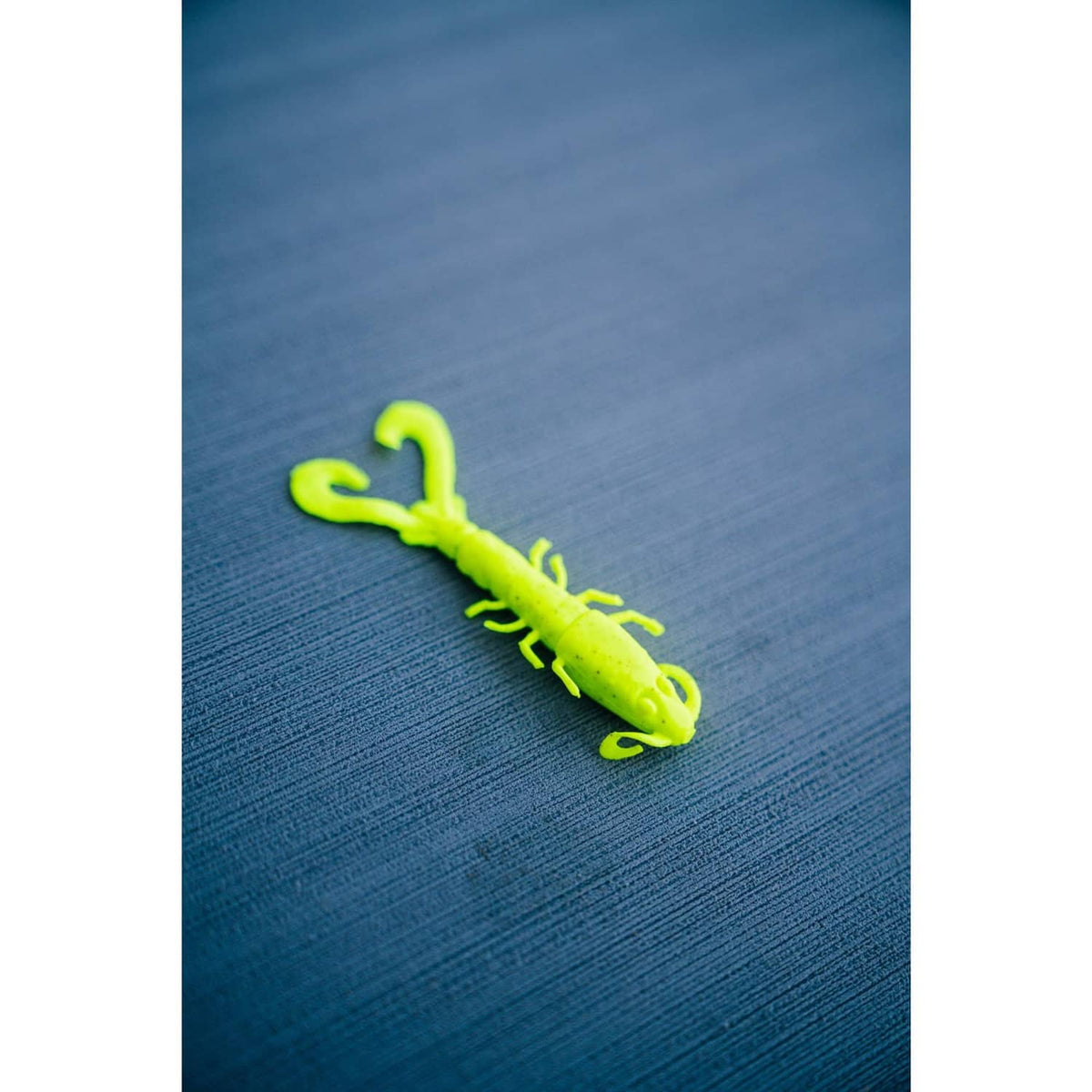 Chartreuse shrimp soft bait on hook, with long antennae and curled tail