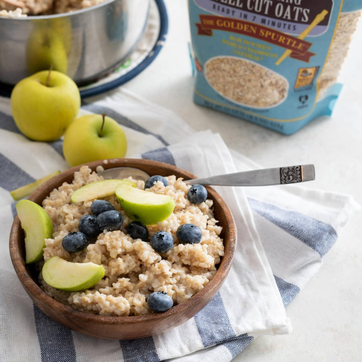Steel cut oats bowl with blueberries and apple slices, Bob's Red Mill pouch in background