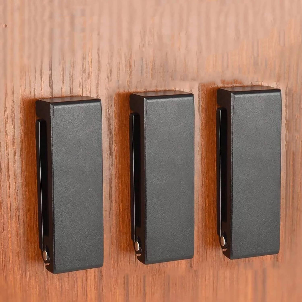 Set of three black folding wall hooks with mounting slots and pivoted arms