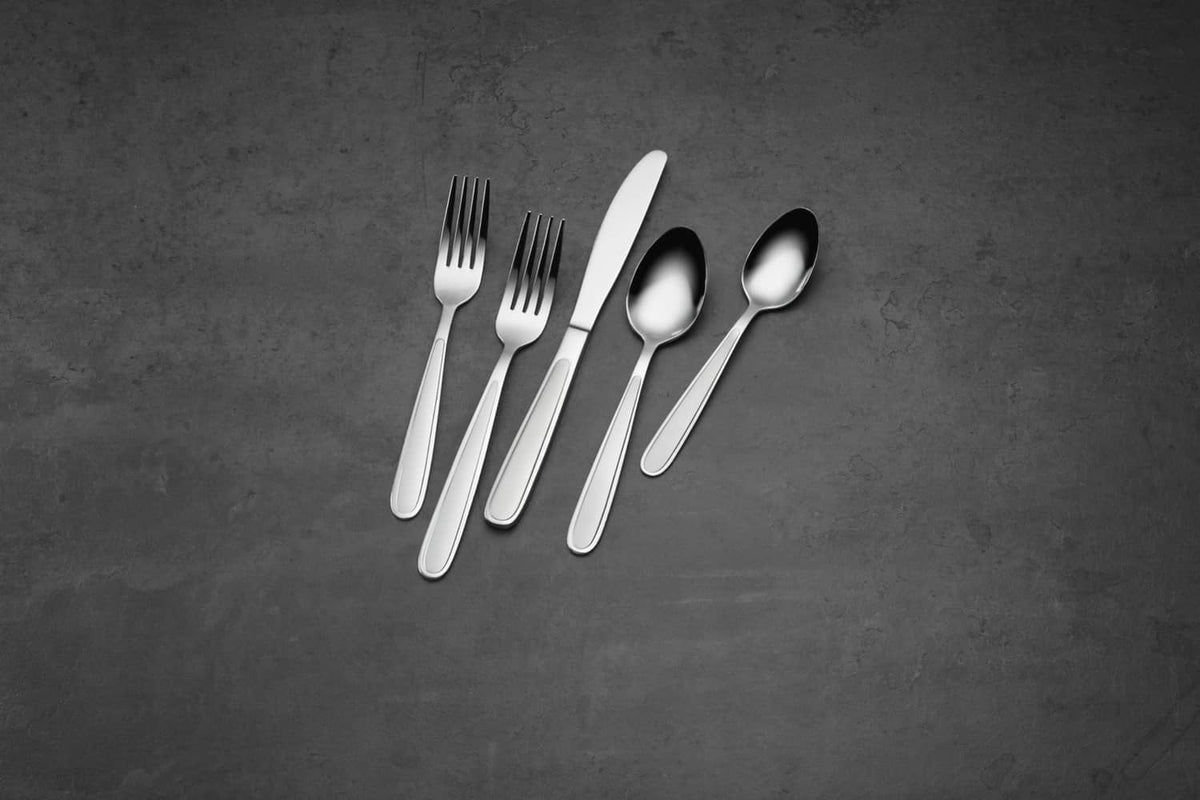 Oneida stainless steel teaspoons in a place setting, reflective oval bowls