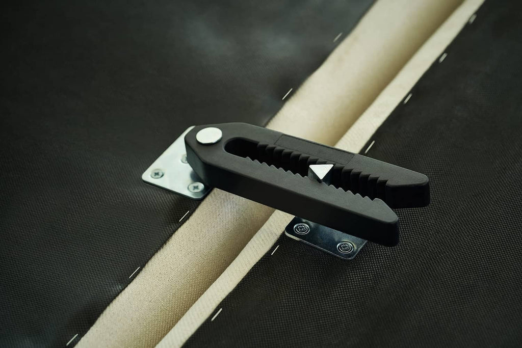 Black serrated connector clamp on upholstery, mounted to metal base plate