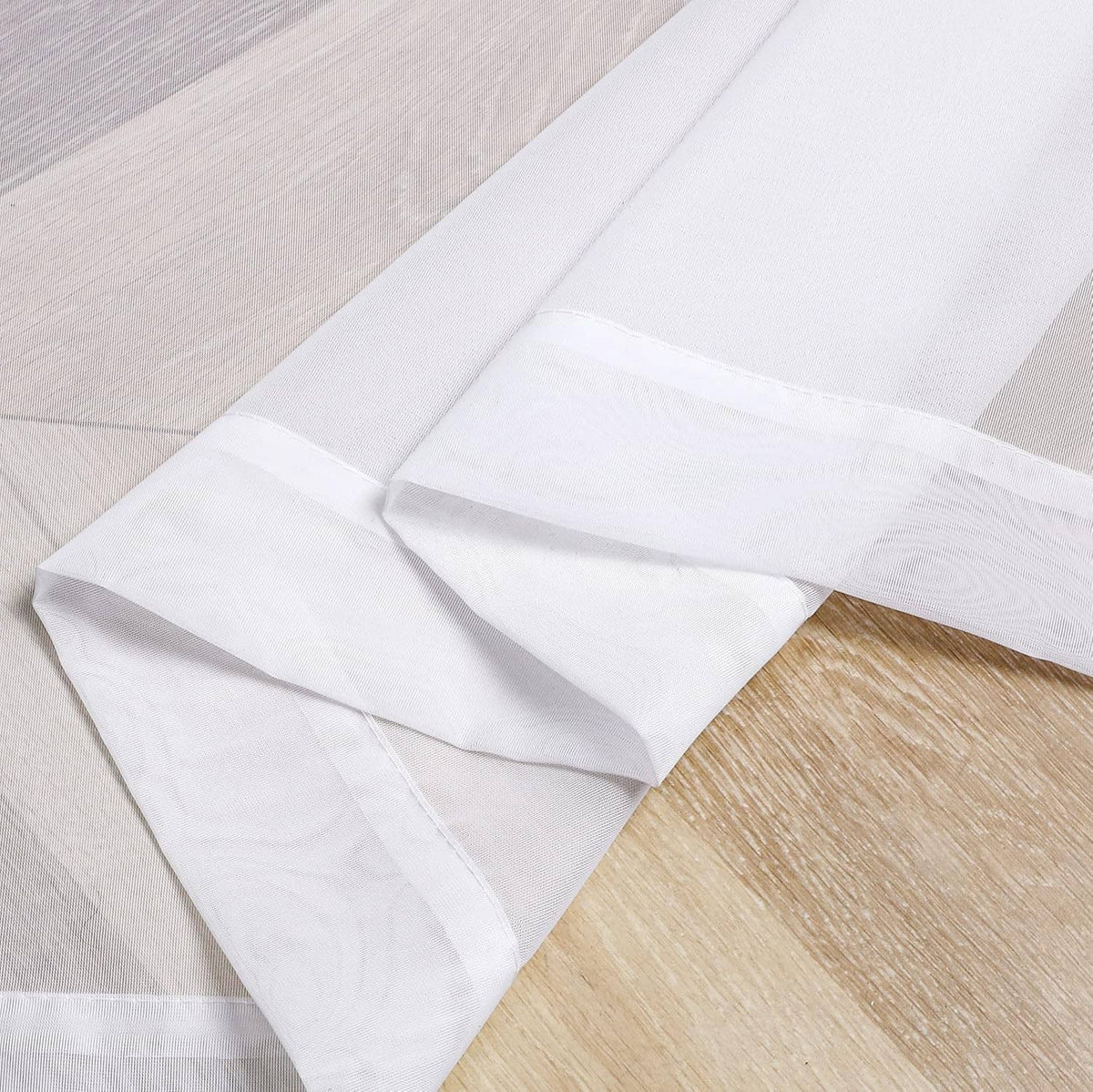 White sheer curtain fabric panels, neatly folded with soft, translucent look