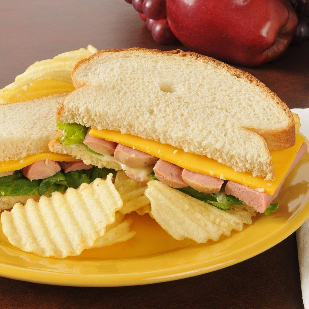 Vienna sausage sandwich on a bun with vegetables and potato chips