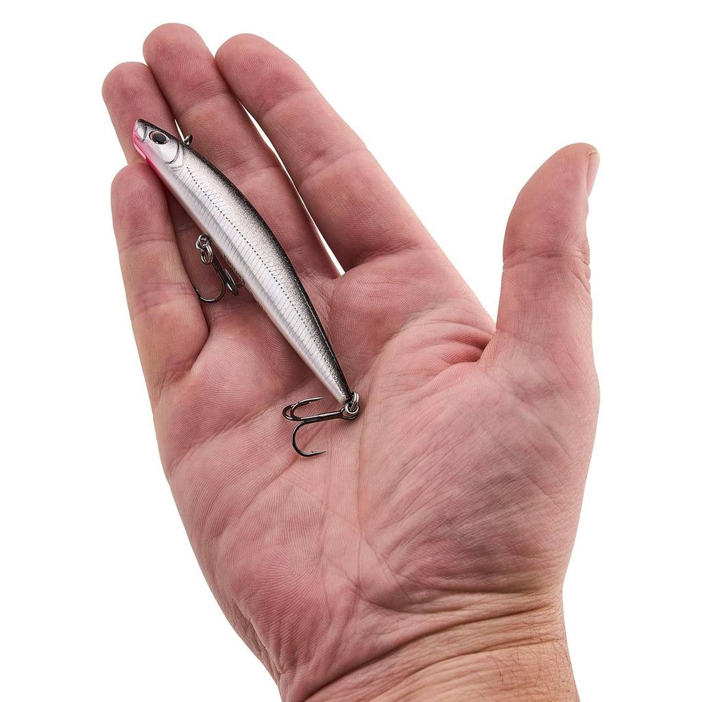 Fishing lure held in hand, silver body with red eye and treble hook