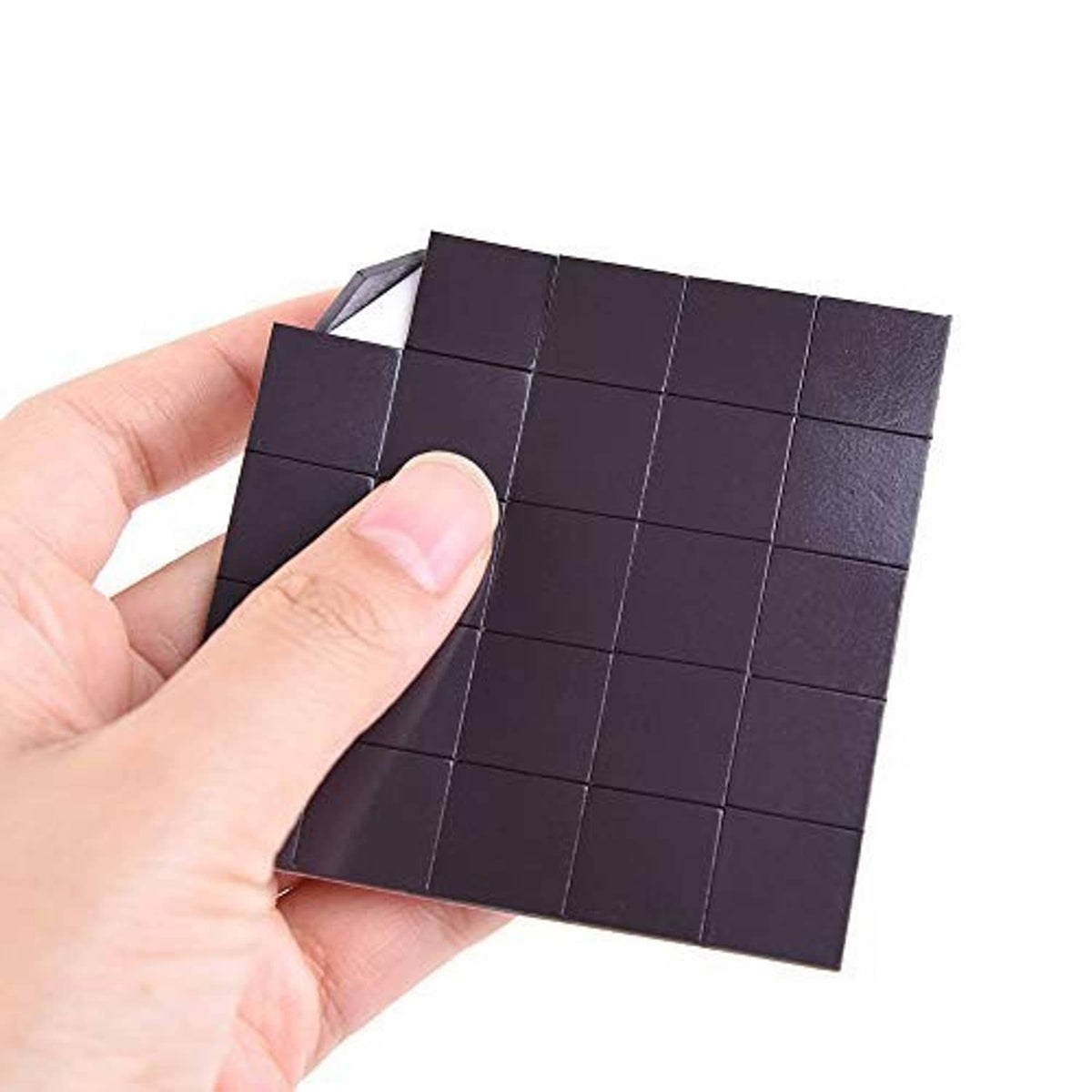 Dark watercolor half pans on magnetic backing, close-up held by fingers