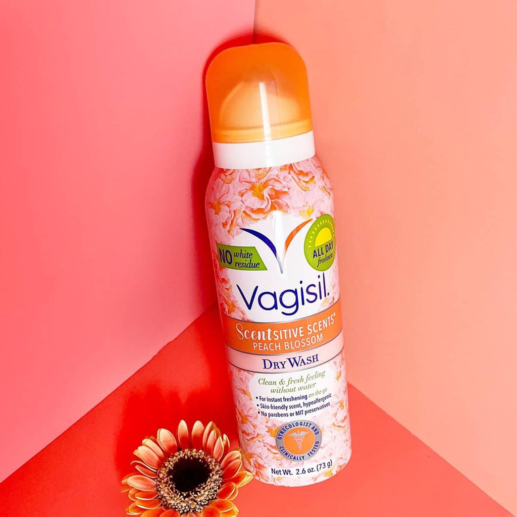 Vagisil dry wash deodorant spray bottle with orange cap, peach blossom scent