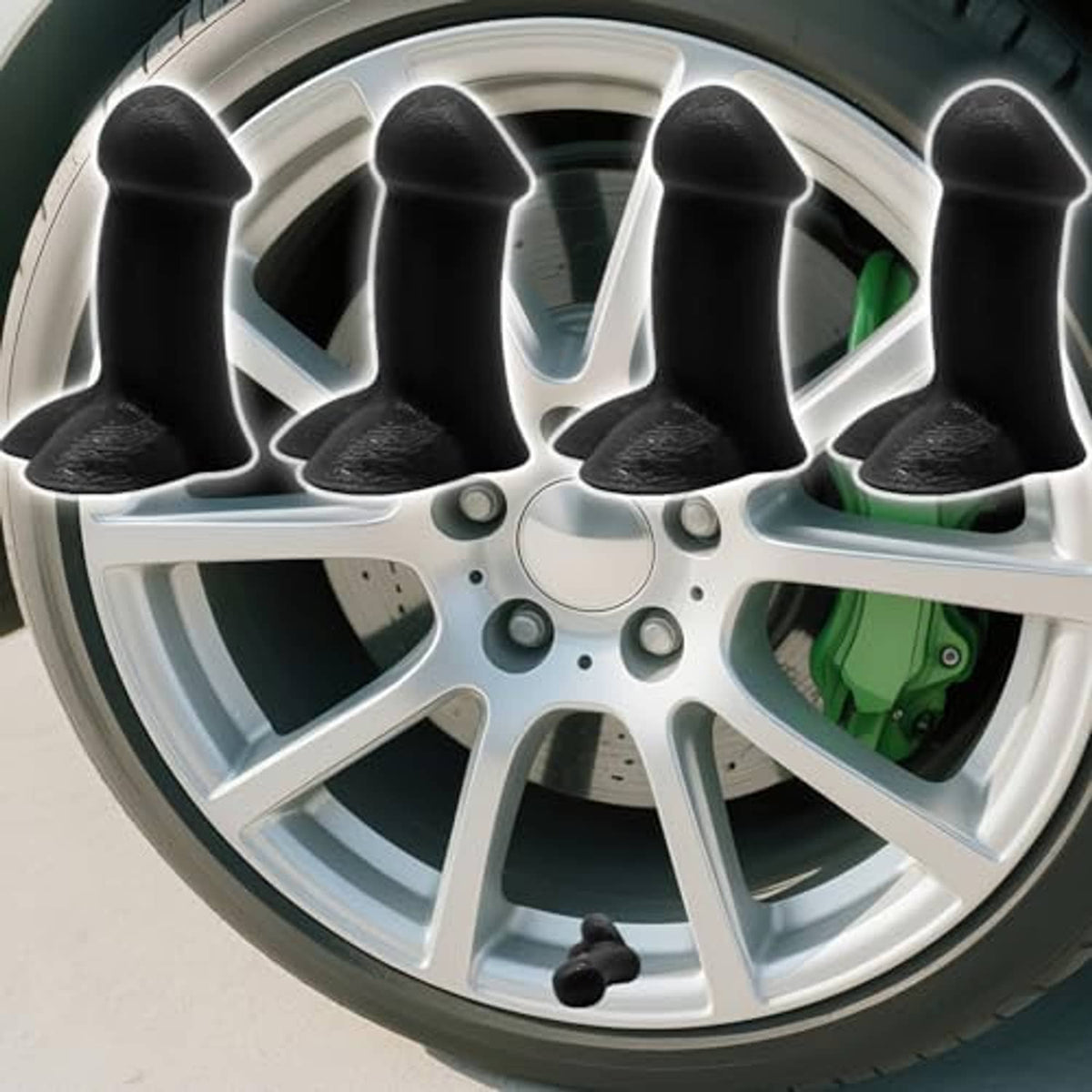 Black cone-shaped tire valve stem caps on a wheel rim, four-piece set