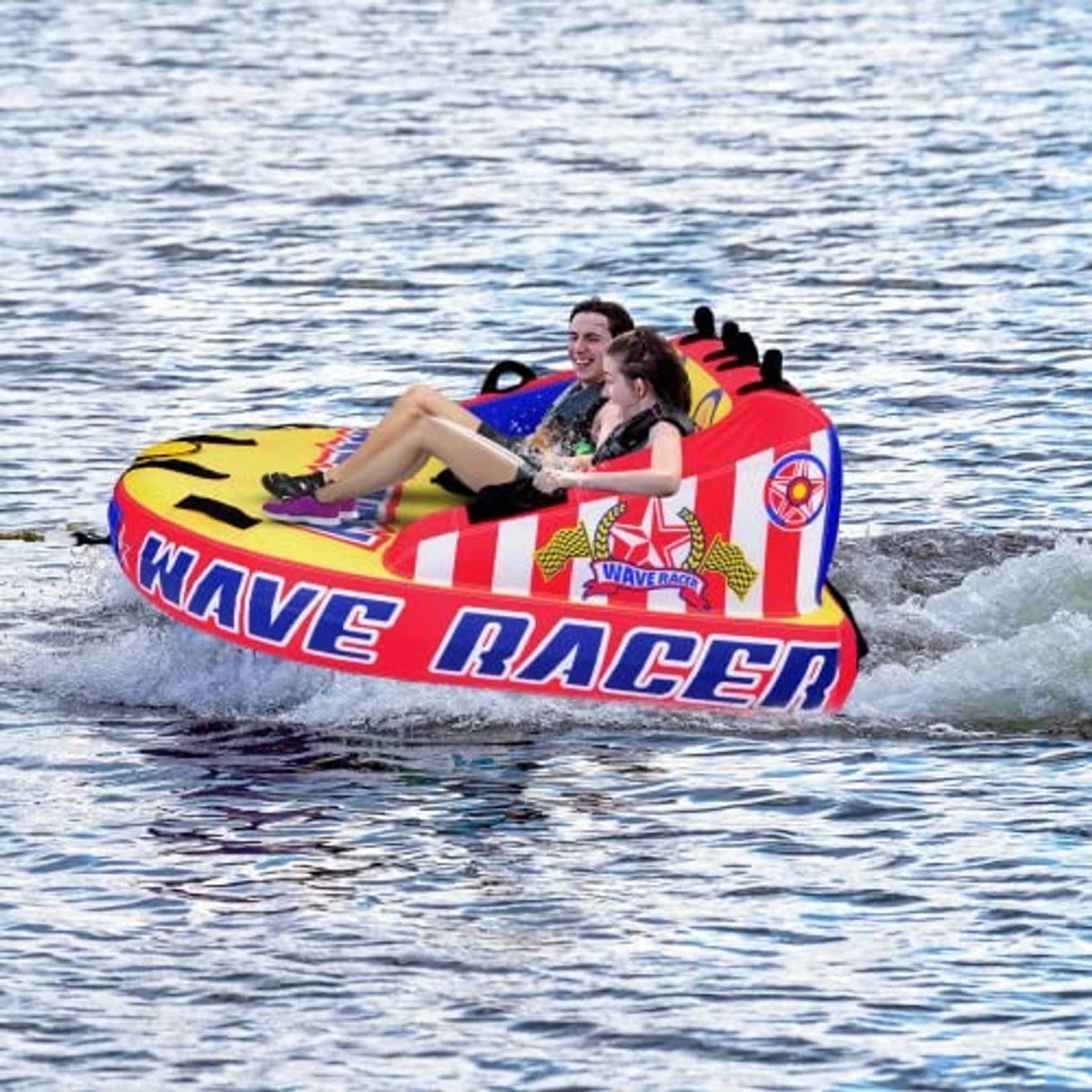 Inflatable wave-racer tow tube with two riders, red and blue body, black handles and backrest