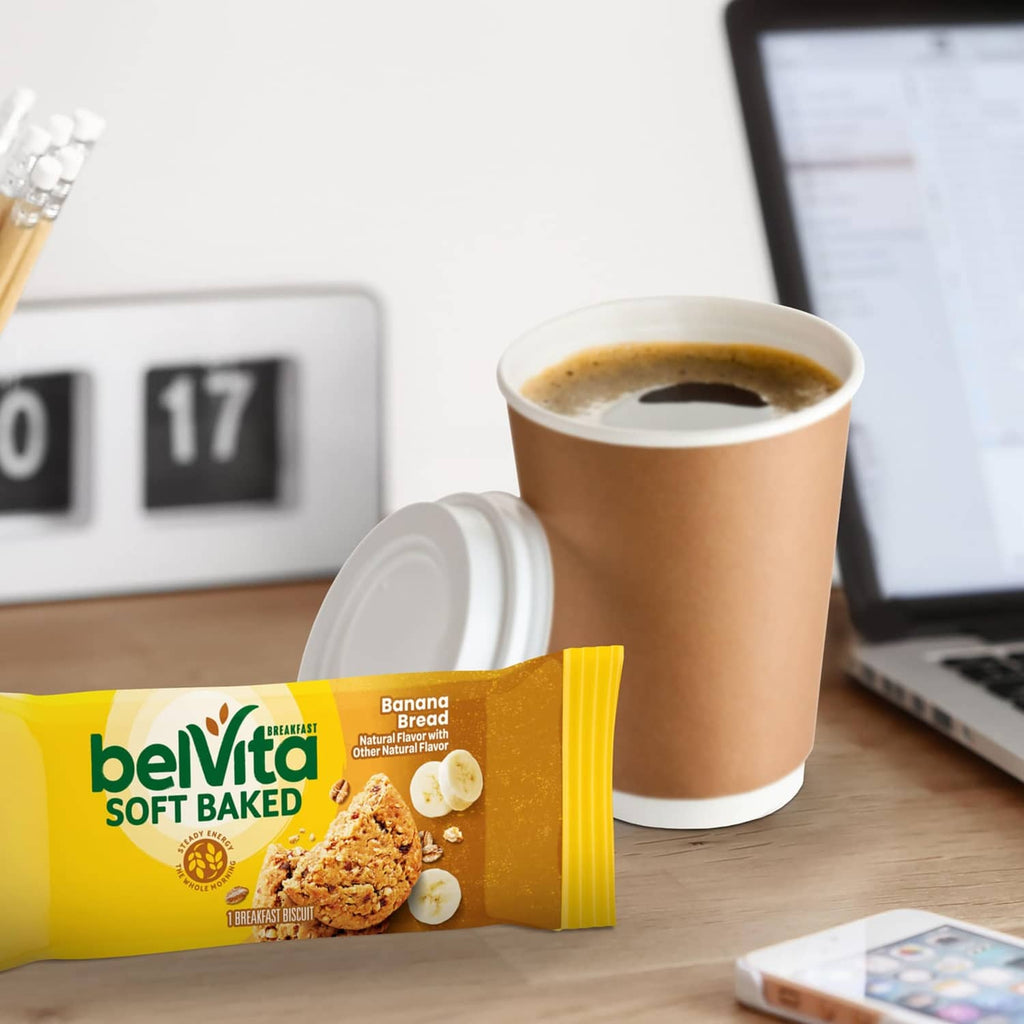 Belvita Soft Baked banana bread biscuit pack with a coffee cup on a desk