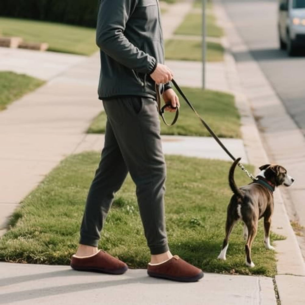 Dark brown slippers on walking feet with casual pants; cream fleece cuff at opening