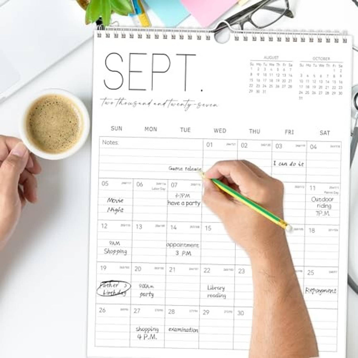 White wall calendar with monthly grid and writable notes, green pen marking dates