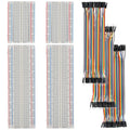Two solderless breadboards with multicolor jumper wires and black connector pins