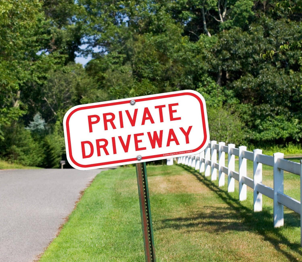 Private Driveway sign on a metal post, white background with red border and lettering