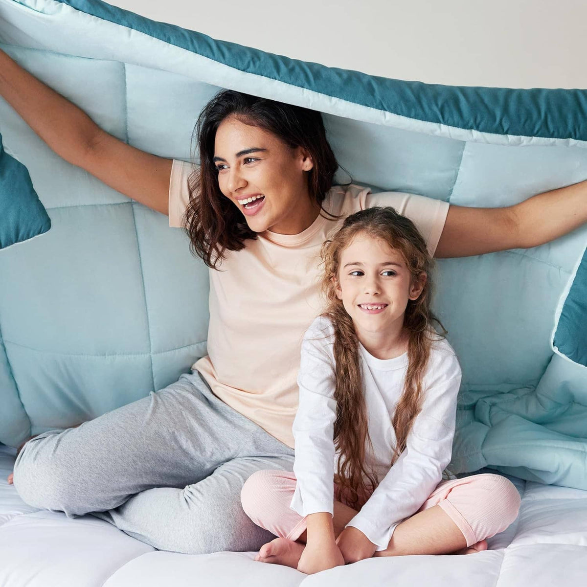 King-size comforter set with teal cover and light-blue lining, styled with two pillows