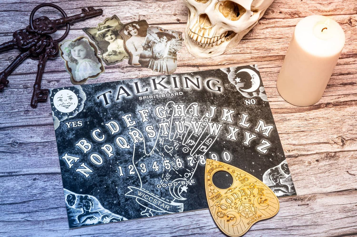 Talking spirit board game with black board, alphabet chart, and gold planchette