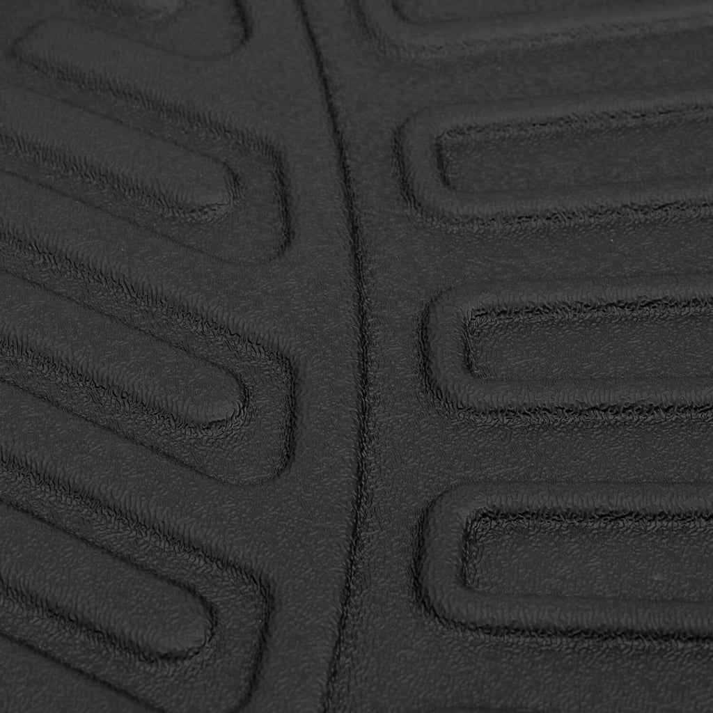 Close-up of black embossed floor mat texture with rectangular tread blocks