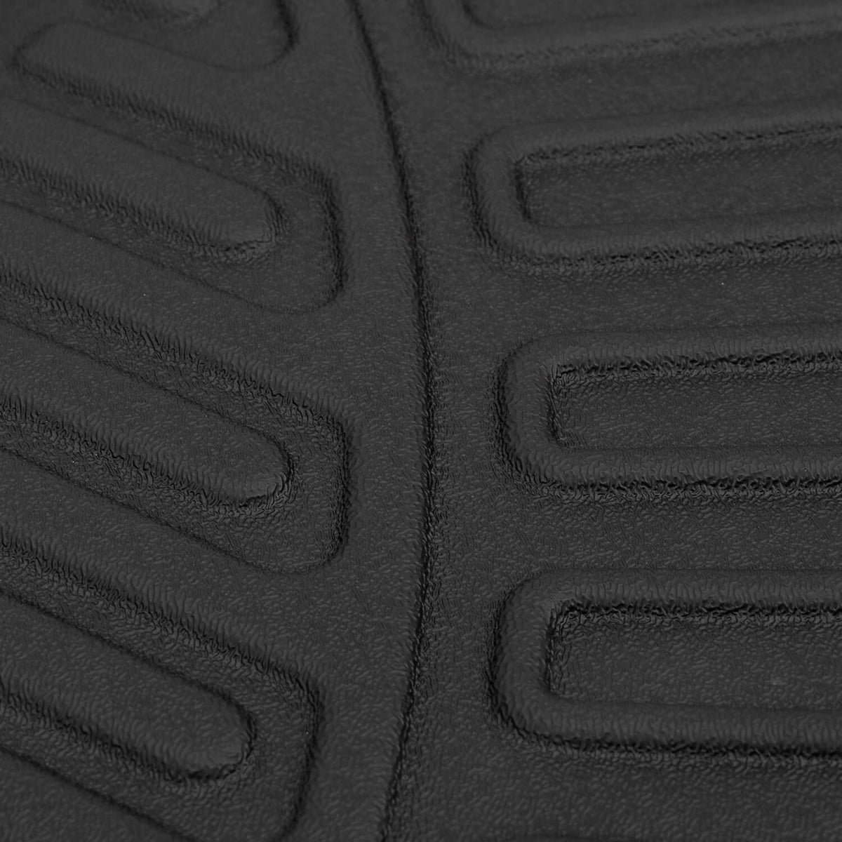 Close-up of black embossed floor mat texture with rectangular tread blocks